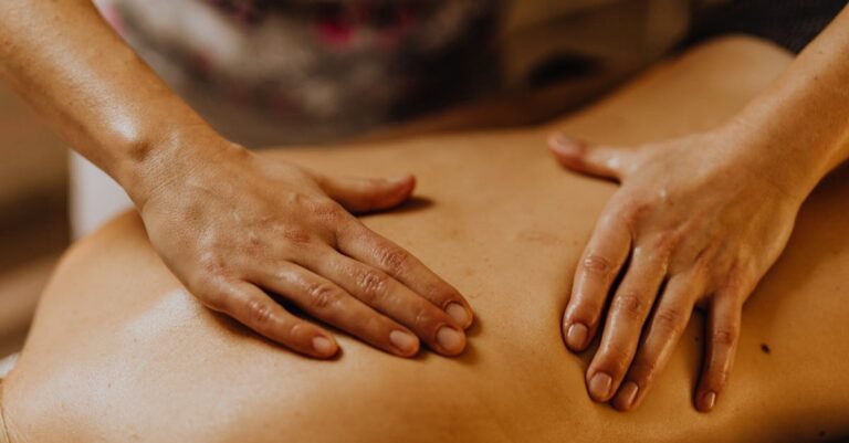 Close-up of hands giving a soothing back massage in a calm setting.